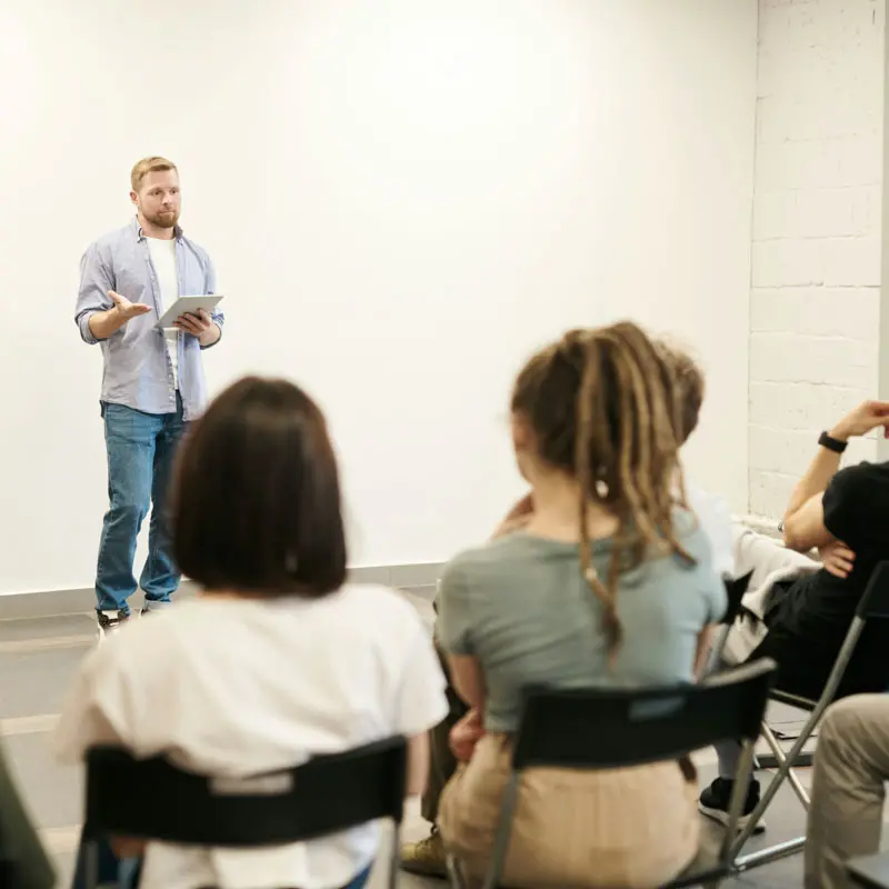 someone talking in front of a group of people